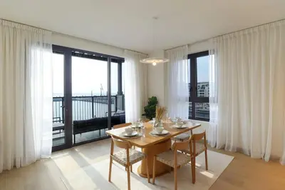 a dining room with a table and chairs and a balcony at HiGuests - Family Dream Escape with Private Beach Access in Dubai