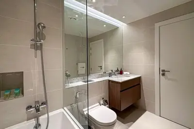 a bathroom with a shower and a toilet and a sink at HiGuests - Dream stay in our Cozy 2BR in La Rive Community in Dubai