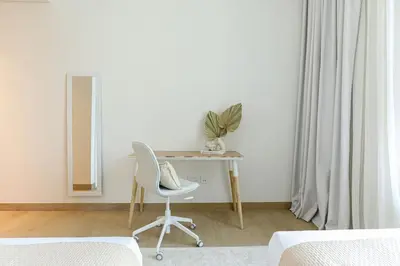 a bedroom with a desk with a chair and a mirror at HiGuests - Dream stay in our Cozy 2BR in La Rive Community in Dubai