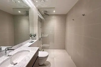 a bathroom with a toilet and a sink and a mirror at HiGuests - Dream stay in our Cozy 2BR in La Rive Community in Dubai