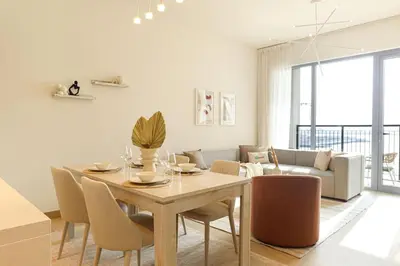 a dining room with a table and chairs at HiGuests - Dream Vacation Apartment in La Rive 1 in Dubai