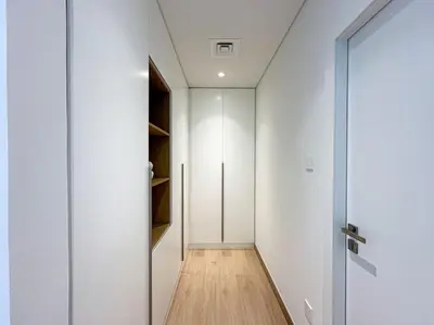 a hallway with white walls and a glass door at HiGuests - Dream Vacation Apartment in La Rive 1 in Dubai