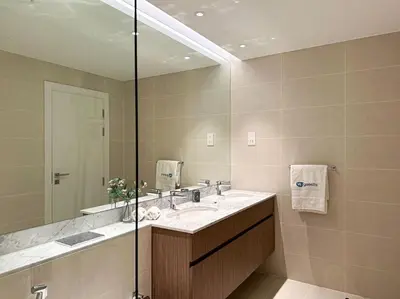 a bathroom with a sink and a large mirror at HiGuests - Dream Vacation Apartment in La Rive 1 in Dubai
