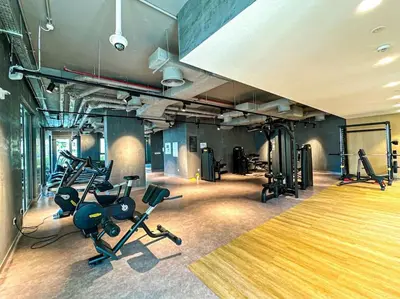 a gym with several treadmills and exercise bikes at HiGuests - Dream Vacation Apartment in La Rive 1 in Dubai