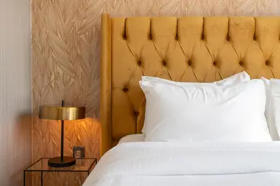 a bedroom with a white bed with a gold headboard at Chic Lux 2BR I High Floor l by Burj Khalifa & Dubai Mall I Pool l Gym in Dubai