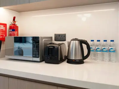 a microwave and a toaster and a coffee maker on a counter at Luxurious & Spacious 2BR l Burj & Fountain Views l Walk to Dubai Mall l Pool l Gym in Dubai