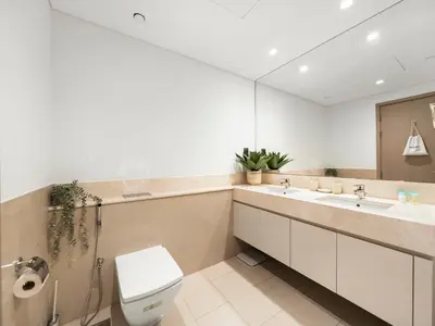 a bathroom with a toilet and two sinks and a mirror at Luxurious & Spacious 2BR l Burj & Fountain Views l Walk to Dubai Mall l Pool l Gym in Dubai