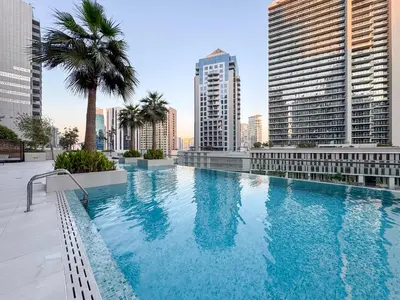 a large swimming pool in a city with tall buildings at Stylish Studio Walk to Dubai Mall & Burj Khalifa in Dubai