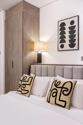 a bedroom with a white bed with black and white pillows at Stylish Studio Walk to Dubai Mall & Burj Khalifa in Dubai