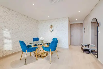 a dining room with a table and blue chairs at Elegant 2-BR Gem Quick Access Downtown Dubai in Dubai
