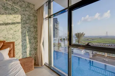 a bedroom with a view of a swimming pool through a window at Elegant 2-BR Gem Quick Access Downtown Dubai in Dubai