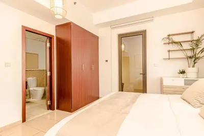 a bedroom with a large bed and a bathroom at GMA Rimal5 4BR Sea View in Dubai
