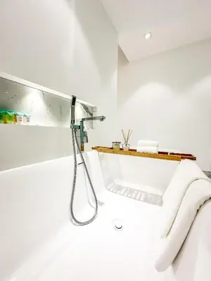 a shower in a white bathroom with white towels at GMA Murjan 2BR Sea View High Floor in Dubai