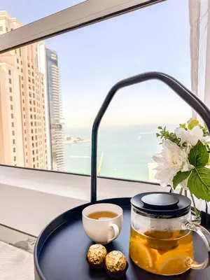 a table with a cup of tea and a cup of coffee at GMA Murjan 2BR Sea View High Floor in Dubai