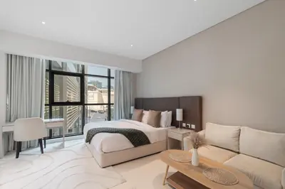 a white bedroom with a bed and a couch at Fully-equipped studio Palm Jumeirah, Seven in Dubai