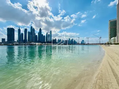 a view of a beach with a city in the background at Marina Vista 1BD with beach access in Beachfront in Dubai