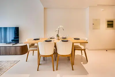 a dining room with a wooden table and chairs at Marina Vista 1BD with beach access in Beachfront in Dubai