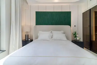 a bedroom with a large white bed with a green headboard at USMANS 4BDRM APARTMENT SEA VIEW Direct BEACH Access Fully Serviced JBR in Dubai