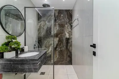 a bathroom with a sink and a shower with a mirror at USMANS 4BDRM APARTMENT SEA VIEW Direct BEACH Access Fully Serviced JBR in Dubai