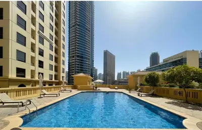 a large swimming pool in a city with tall buildings at USMANS 4BDRM APARTMENT SEA VIEW Direct BEACH Access Fully Serviced JBR in Dubai