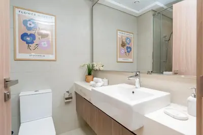 a bathroom with a sink and a toilet and a mirror at ON OFF HH-Meydan One- Cozy STUDIO - Burj Khalifa & Lagoon view in Dubai