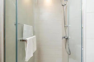 a shower with a glass shower door with a towel at ON OFF HH-Meydan One- Cozy STUDIO - Burj Khalifa & Lagoon view in Dubai