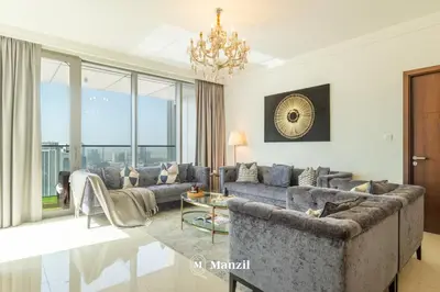 a living room with couches and a chandelier at Manzil - 3BR in Boulevard Point connected to Dubai Mall with Incredible View of Burj Khalifa in Dubai