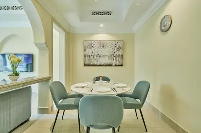 a dining room with a table and chairs at Golden Homes Souk Al Bahar Burj khalifa view Tajer residences 1BR Mint avenue Near , Dubai mall & burj khalifa in Dubai