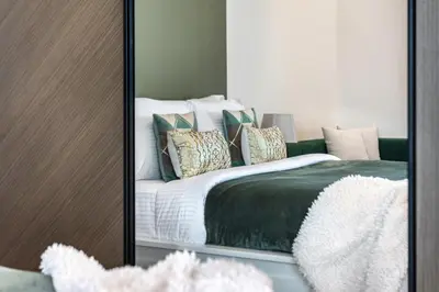 a mirror reflection of a bed in a bedroom at The Smart Concierge - Binghatti Canal in Dubai