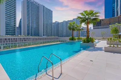 a swimming pool on the roof of a building with tall buildings at Voguish studio! Walk to Burj Khalifasleeps 3! in Dubai