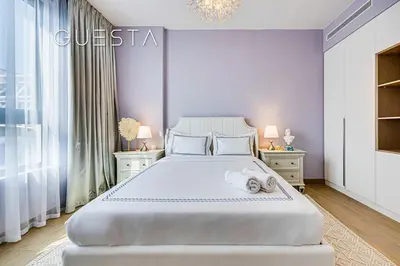 a bedroom with a large white bed with two night stands at La Voile by Merass, La Mer Dubai in Dubai