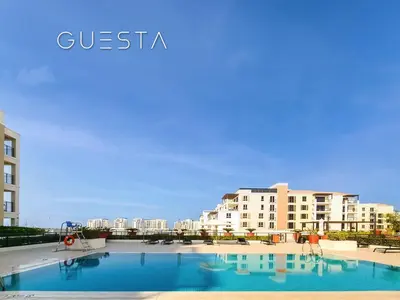a large swimming pool in front of some buildings at La Voile by Merass, La Mer Dubai in Dubai