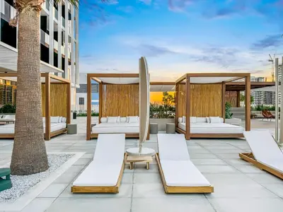 a patio with lounge chairs and a gazebo with a surfboard at FAM Living - Upside Living - WFH Friendly-Business Bay in Dubai