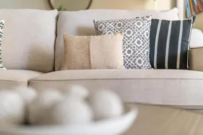 a living room with a couch with pillows and a table at GuestReady - Beachside Escape near Marina Beach in Dubai