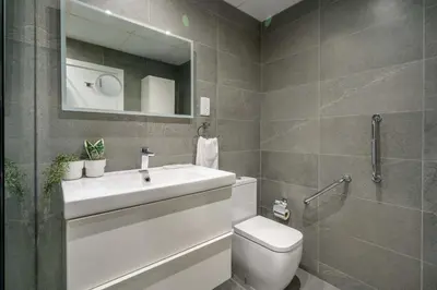 a bathroom with a sink and a toilet and a mirror at GuestReady - Beachside Escape near Marina Beach in Dubai