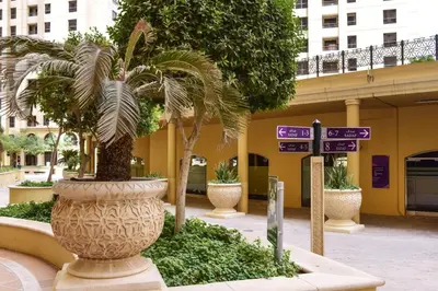 a large vase with a palm tree in front of a building at GuestReady - Beachside Escape near Marina Beach in Dubai