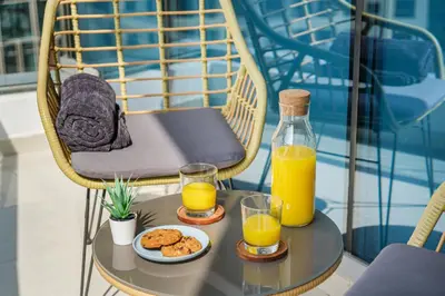 a table with two glasses of orange juice and cookies at Iolanda Home in Dubai