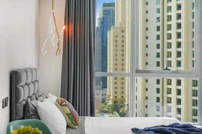 a bedroom with a window with a view of a city at Iolanda Home in Dubai