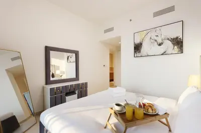 a white bedroom with a tray of food on a bed at Luxury 3B and maids Burj View, Steps to Dubai Mall in Dubai