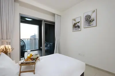 a white bedroom with a bed and a window at Luxury 3B and maids Burj View, Steps to Dubai Mall in Dubai