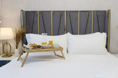 a bed with a tray of food and drinks on it at Luxury 3B and maids Burj View, Steps to Dubai Mall in Dubai