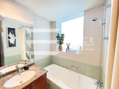 a bathroom with a tub and a sink and a window at 1 Bedroom Apartment in JLT in Dubai