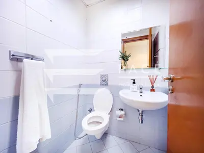 a white bathroom with a toilet and a sink at 1 Bedroom Apartment in JLT in Dubai