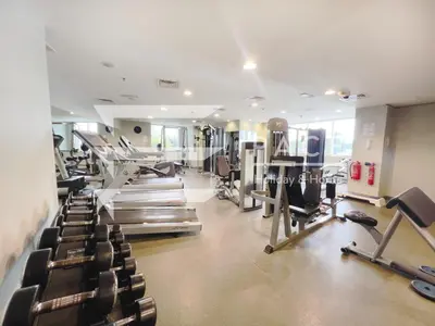a gym with rows of treadmills and machines at 1 Bedroom Apartment in JLT in Dubai