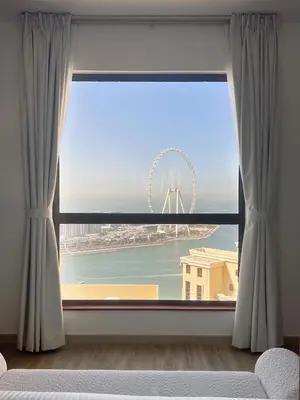 a large window with a view of a ferris wheel at GMA Amwaj 2BR Sea View High Floor in Dubai
