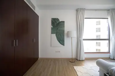 a living room with a large window and a couch at GMA Amwaj 2BR Sea View High Floor in Dubai