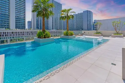 a swimming pool on the roof of a building with palm trees at Trendy Studio! Walk to Burj Khalifasleeps 3! in Dubai