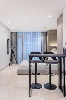 a living room with a table and two stools at Designer Glam Studio Steps from Burj Khalifa in Dubai