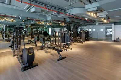 a gym with several treadmills and elliptical machines at Designer Glam Studio Steps from Burj Khalifa in Dubai