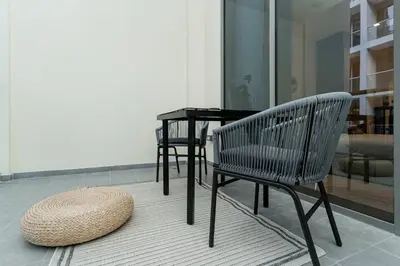 a straw hat sitting next to a bench and a table at Designer Glam Studio Steps from Burj Khalifa in Dubai